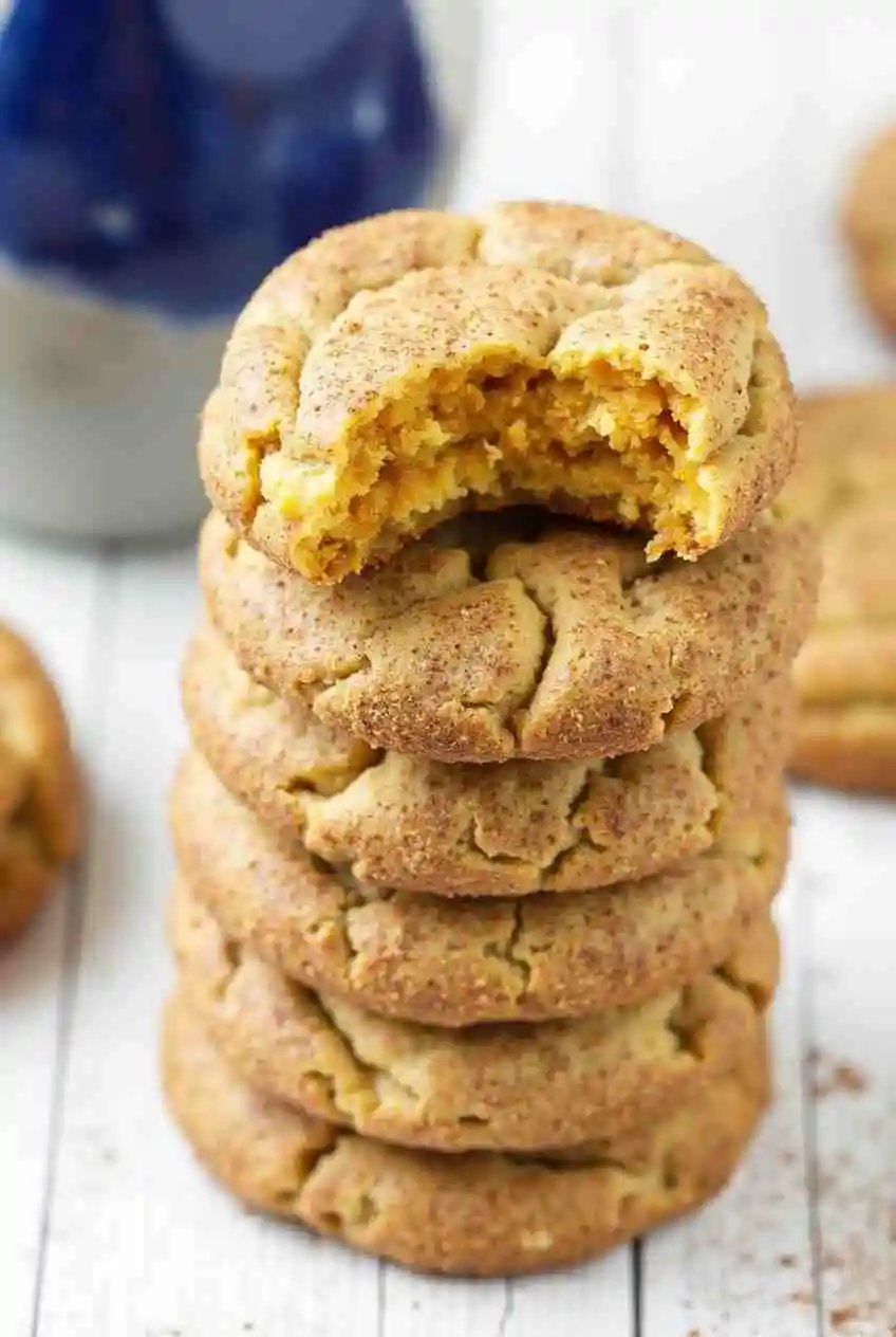 Freshly baked Pumpkin Snickerdoodles with cinnamon sugar coating on a rustic wooden table